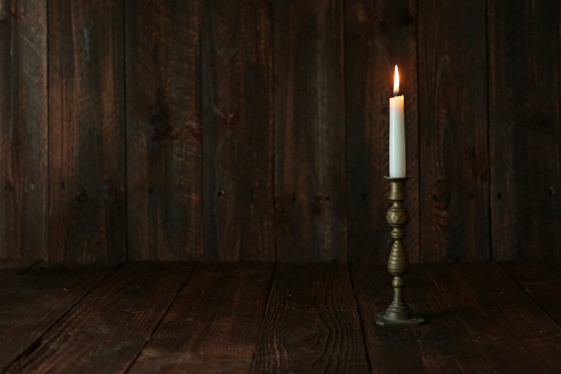 6971652-lit-candle-on-an-old-wooden-rustic-background