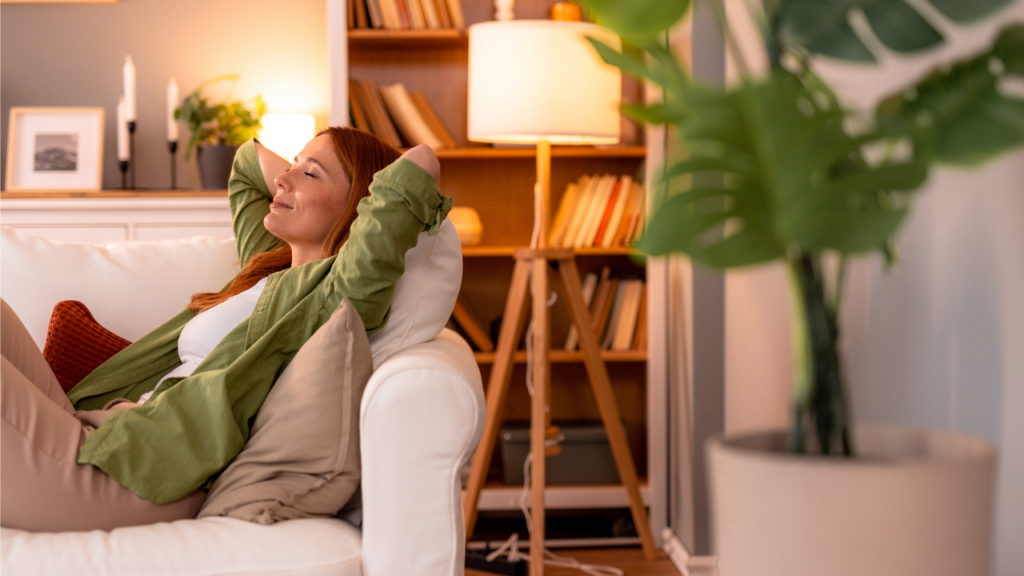 En person ligger i soffan och tar det lugnt.